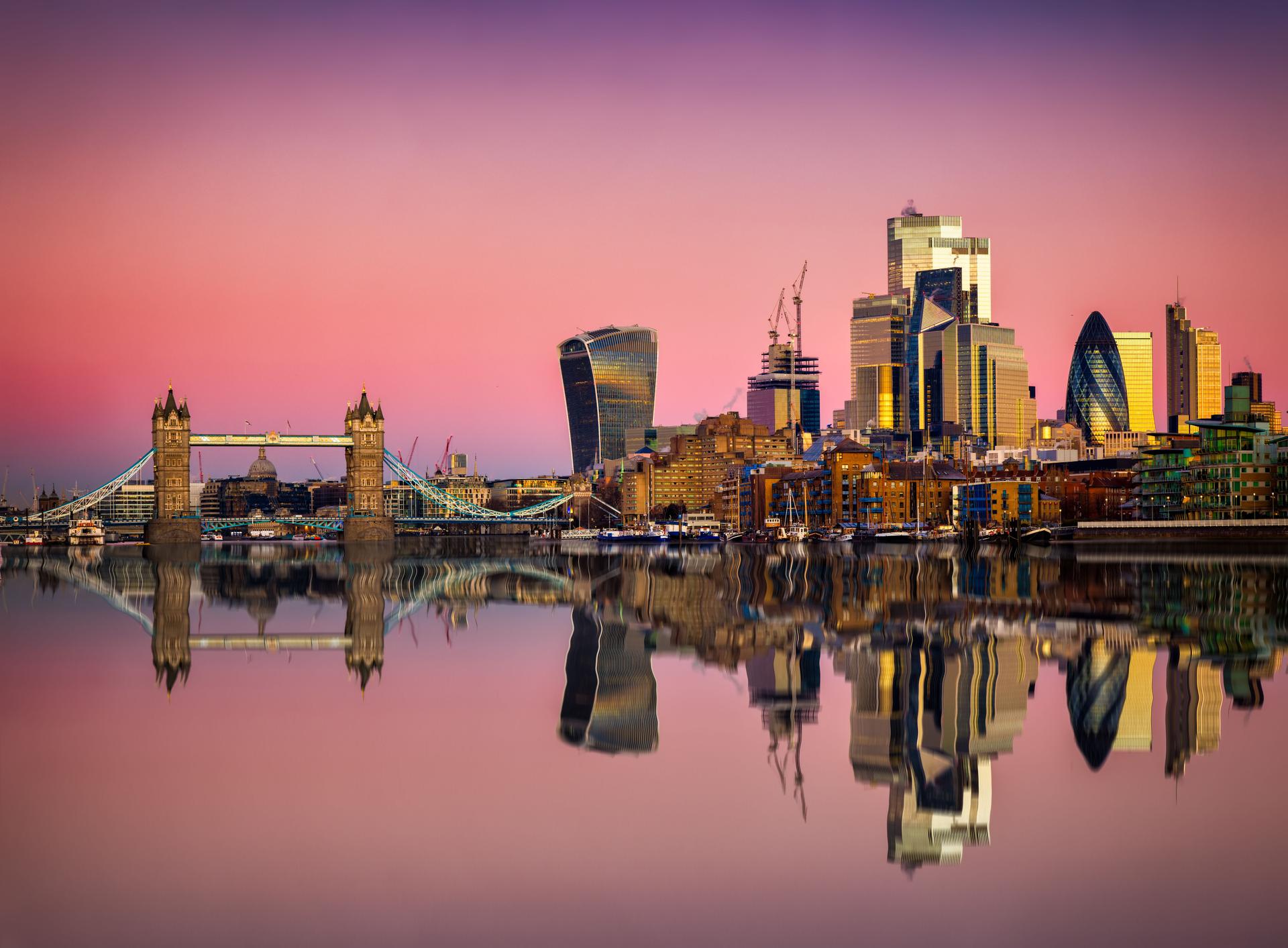 The skyline of the City of London and Tower Bridge during pink dawn